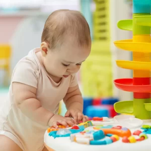 Baby exploring colourful toys during early developmental play